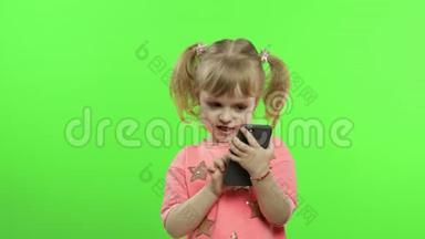 小女孩用智能手机。 有智能手机发短信、玩游戏的儿童肖像